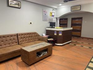 a living room with a couch and a desk at Milan Hotel in Zahirābād