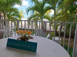 a white table with a sign on top of it at Just in paradise in Baie Nettle
