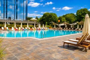 a large swimming pool with lounge chairs and umbrellas at Sheraton Istanbul Atakoy Hotel in Istanbul