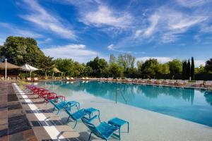 a large swimming pool with blue and red chairs at Sheraton Istanbul Atakoy Hotel in Istanbul +138 photos