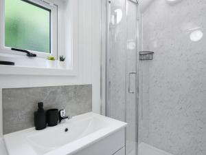 a white bathroom with a sink and a shower at Mini Lodge - Uk47682 in Montgomery +4 photos