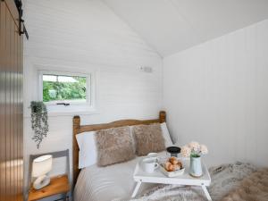 a bedroom with a bed and a table with a tray of food at Mini Lodge - Uk47682 in Montgomery