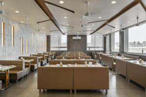 an empty dining room with tables and chairs at Hotel Fountain - Kamrej in Surat