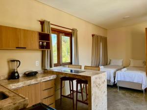 a room with a kitchen and a bedroom with a bed at Pousada Veleiro Kite Preá in Prea
