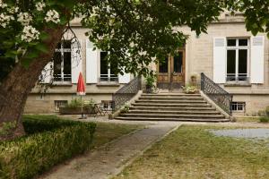 a building with stairs and a door and a tree at Chateau Gioux in Saint-Pierre-Bellevue