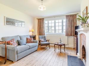a living room with a couch and a fireplace at Mark Farmhouse in Bradwell on Sea