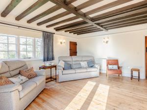 a living room with two couches and a table at Mark Farmhouse in Bradwell on Sea
