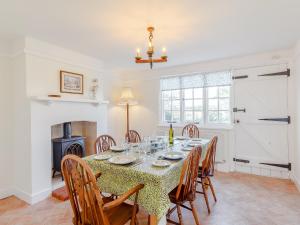 a dining room with a table with chairs and a fireplace at Mark Farmhouse in Bradwell on Sea