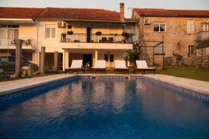 a swimming pool in front of a house at Maison Des Oliviers in Herceg-Novi