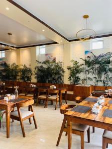 a restaurant with wooden tables and plants on the walls at Pine Tree Resort in Nagarkot