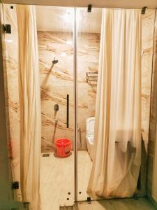 a bathroom with a glass shower with a toilet at Baga Ocean Way in Baga