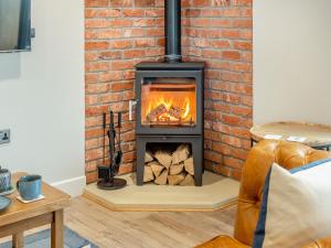 a fireplace in a living room with a brick wall at The Workshop - Uk42470 in Middleton +24 photos