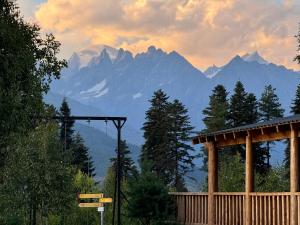 a view of a mountain range with a wooden gazebo at Chalet Hatsvali - Ushba Viewpoint Rooms & Café in Mestia
