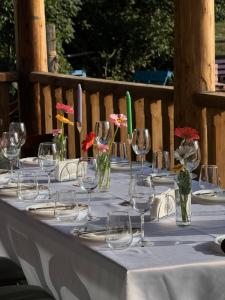 a table with wine glasses and flowers on it at Chalet Hatsvali - Ushba Viewpoint Rooms & Café in Mestia
