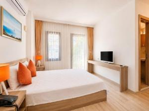 a bedroom with a white bed and a television at Aria Doria Otel in Datca