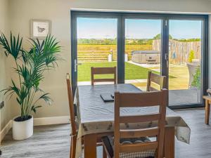 a dining room with a table and a view of a garden at The Old Dairy - Uk31253 in Middleton