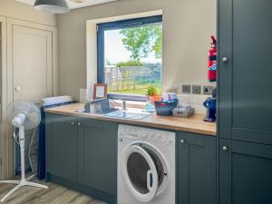 a kitchen with a washing machine and a sink at The Old Dairy - Uk31253 in Middleton +16 photos