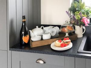 a counter with a bottle of wine and a plate of food at The Old Dairy - Uk31253 in Middleton