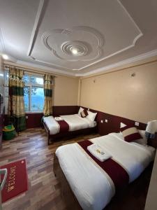 a hotel room with two beds and a window at Pahuna Ghar Homestay in Tānsen +24 photos
