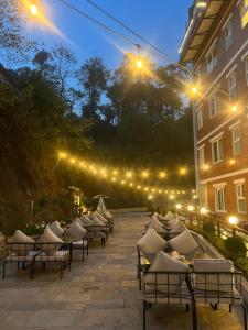 a row of chairs sitting on a patio at night at Pine Tree Resort in Nagarkot