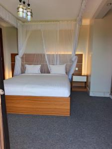 a bedroom with a white bed with a canopy at Masese Heights in Jinja