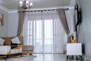 a living room with a couch and a large window at Masese Heights in Jinja