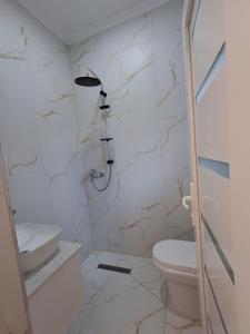 a white bathroom with a toilet and a sink at Hotel Bar Restorant RRAHIMI in Shënmëri +47 photos