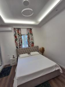 a bedroom with a large white bed with a window at Hotel Bar Restorant RRAHIMI in Shënmëri