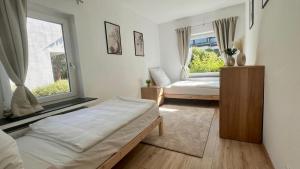 a bedroom with two beds and a window at Stilvolles Apartment im Siebengebirge in Königswinter