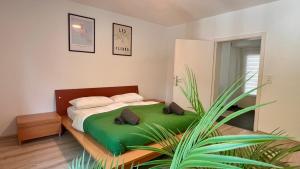 a bedroom with a green bed with a plant at Stilvolles Apartment im Siebengebirge in Königswinter
