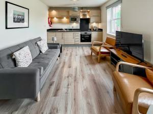 a living room with a couch and a kitchen at Solara Breeze in Filey