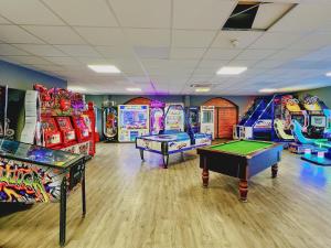 a gaming room with two pool tables and arcade machines at Solara Breeze in Filey