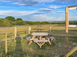 a picnic table in a field next to a fence at Solara Breeze in Filey