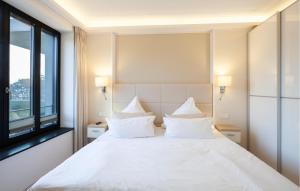 a bedroom with a large white bed with white pillows at Princess in Binz