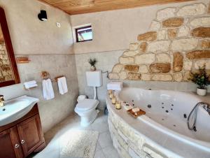 a bathroom with a tub and a toilet and a sink at Villa Stone House Poplat in Vela Luka +88 photos