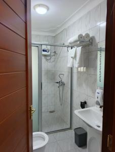 a bathroom with a shower and a toilet and a sink at Masese Heights in Jinja +15 photos