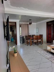 a living room with a table and a dining room at Masese Heights in Jinja