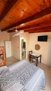a bedroom with a bed and a table and a ceiling at Hostel Maranata in Puerto Madryn