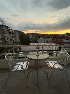 a table and chairs on a balcony with a candle on it at Ajazi Rooms in Struga