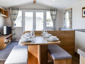 a dining room and kitchen with a wooden table and chairs at The Hideaway - Uk49292 in Morecambe