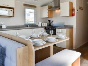 a kitchen with a table with plates and wine glasses at The Hideaway - Uk49292 in Morecambe