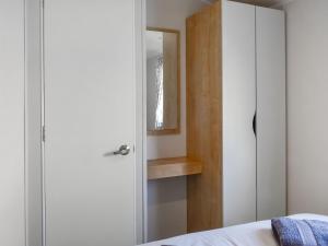 a bedroom with a white closet and a mirror at The Hideaway - Uk49292 in Morecambe