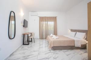 a bedroom with a bed and a table and a mirror at Dorians - Faliraki in Faliraki
