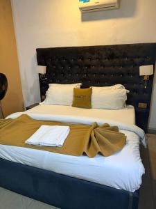 a bedroom with a large bed with a brown blanket at Mareot Hotel and Lounge in Maiyegun