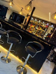 a bar with three chairs in front of a counter at Mareot Hotel and Lounge in Maiyegun