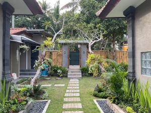 a garden with a blue door in a house at Bendul Retreat in Tabanan +6 photos