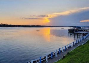 a dock on a lake with the sun setting at Casa Completa no Centro de Soure com Wi fi e Garagem in Soure