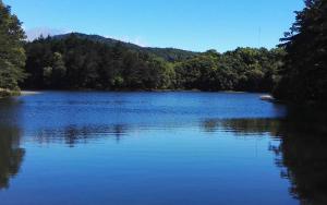 a large blue lake with trees in the background at Quinta Galeon Lodge in Santa María