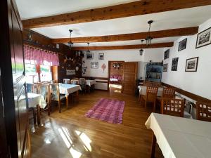a dining room with tables and chairs and a room with a table at Goralské chalupy in Zálesie