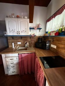 a kitchen with white cabinets and a sink at Goralské chalupy in Zálesie +3 photos
